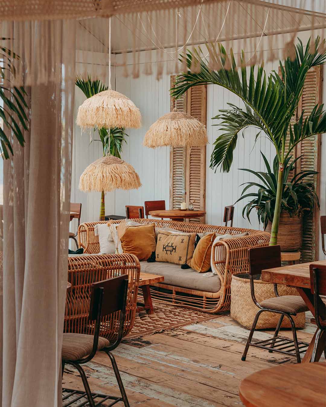 Loungehoek bij Tulum met rotan bank en grote planten