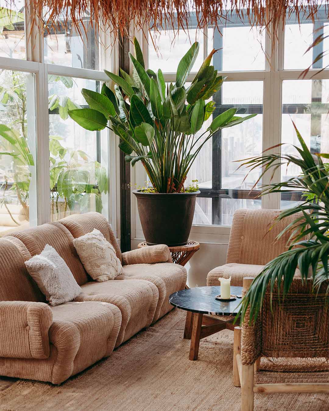 Loungehoek bij Branding met beige bank en grote planten