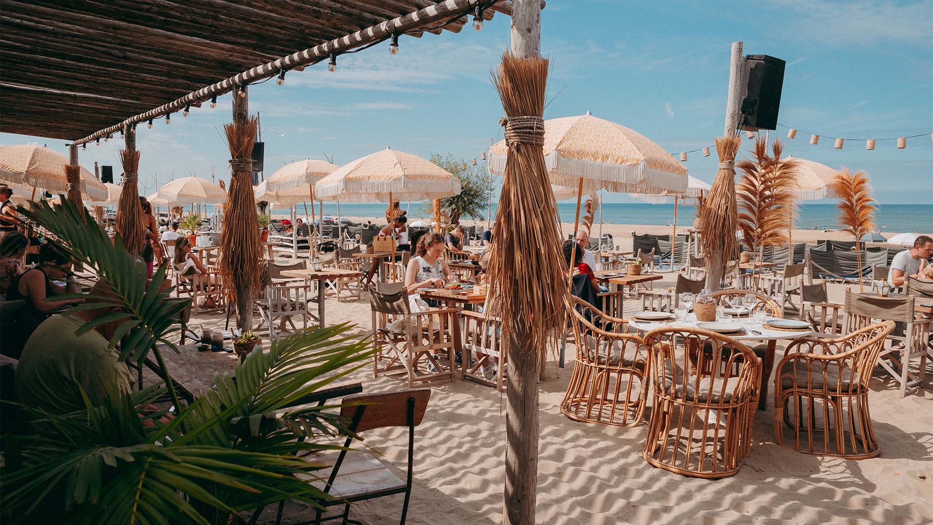 Exterieur shot loungehoek met meubels van Ibiza Outdoor in het zand met blauwe lucht