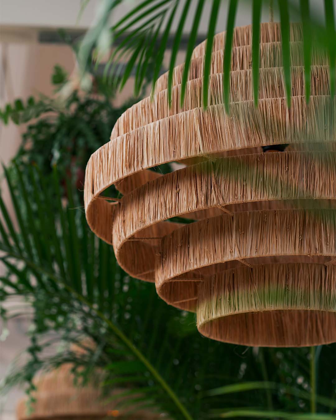 Rotanlamp tussen de groene planten