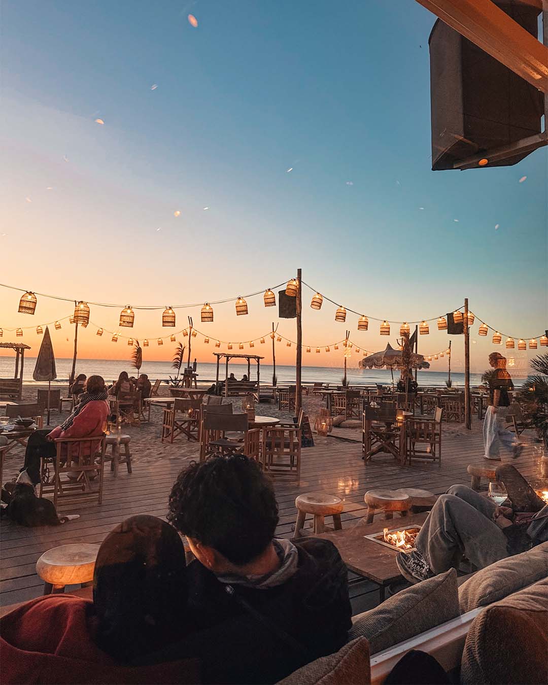 Gasten buiten op het terras met ondergaande zon