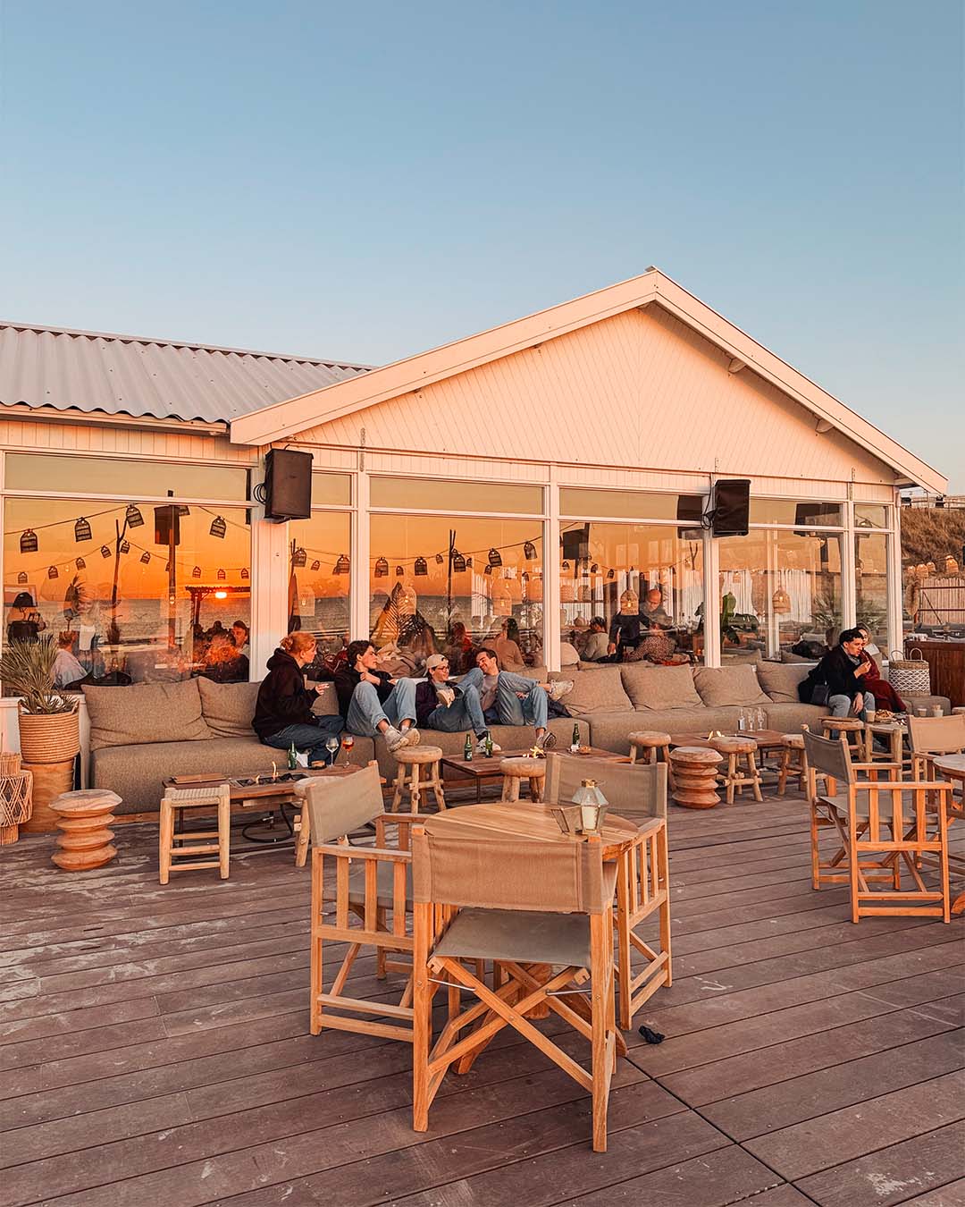 Gasten buiten op het terras met ondergaande zon