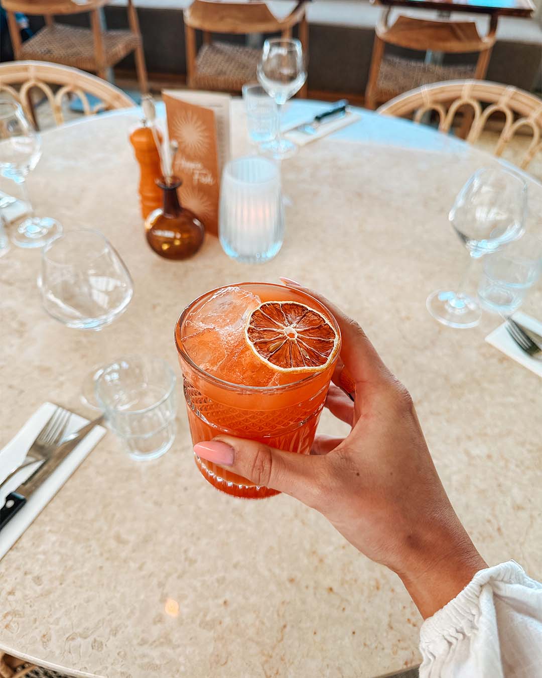 Amber Kiss cocktail in hand