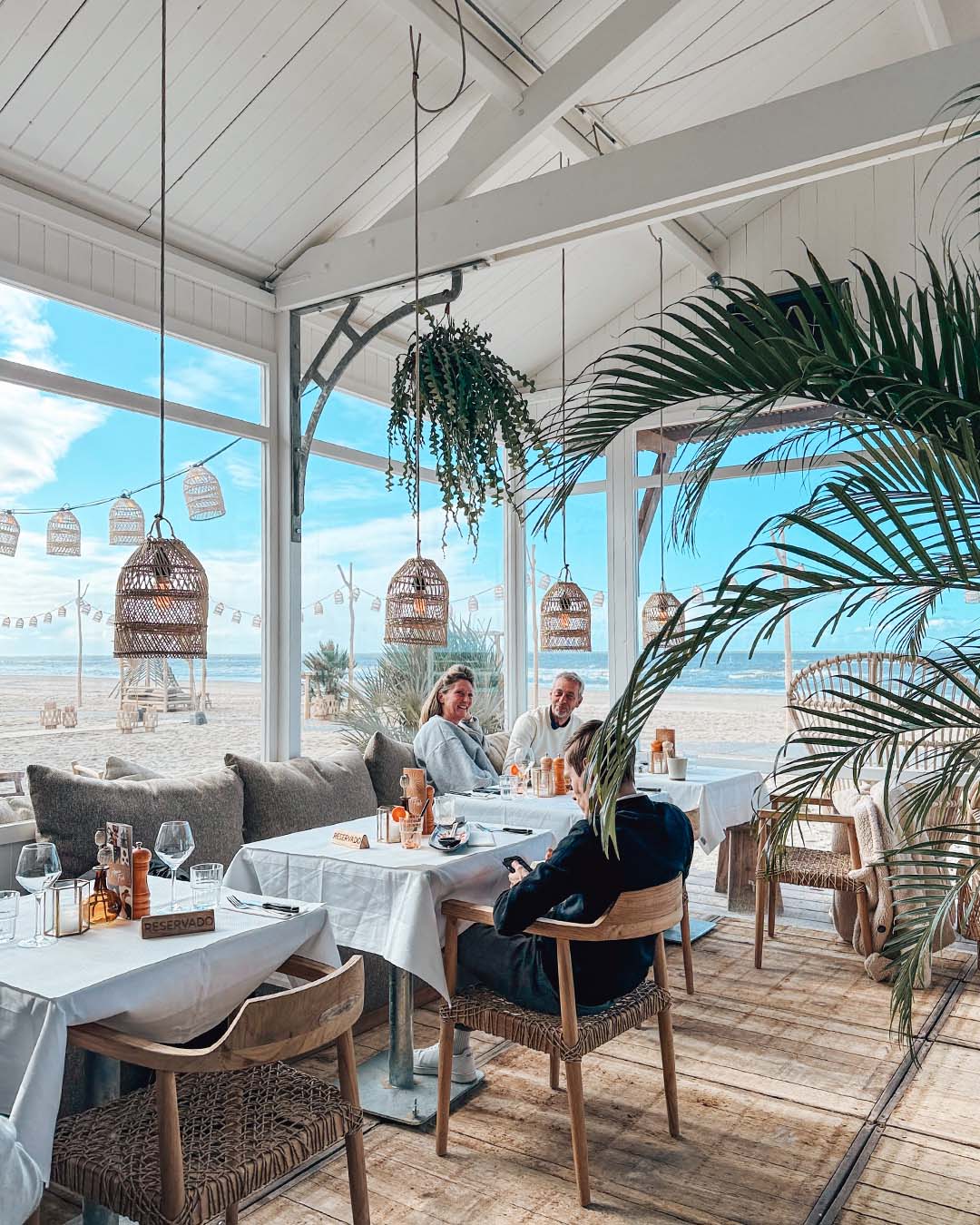 Tafels met gasten met blauwe lucht buiten