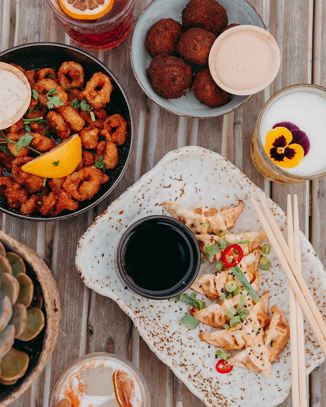 Bovenaanzicht borrel met gyoza's, calamaris en cocktails