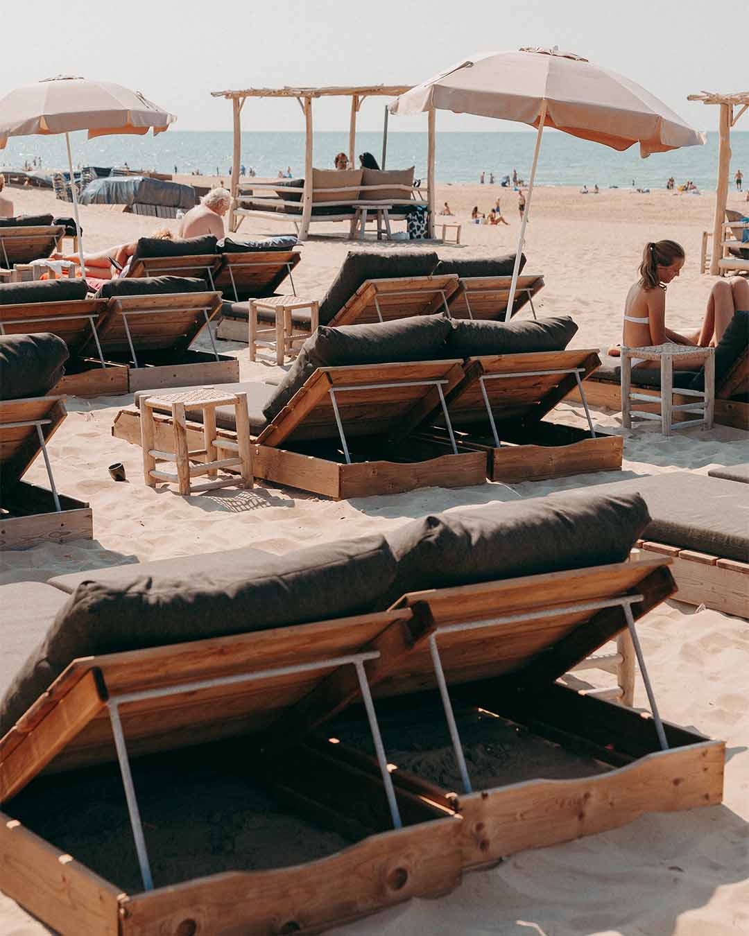 Ligbedden met parasols op het strand