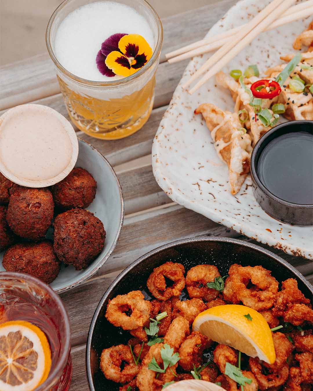 Bovenaanzicht borrel met gyoza's, calamaris en cocktails