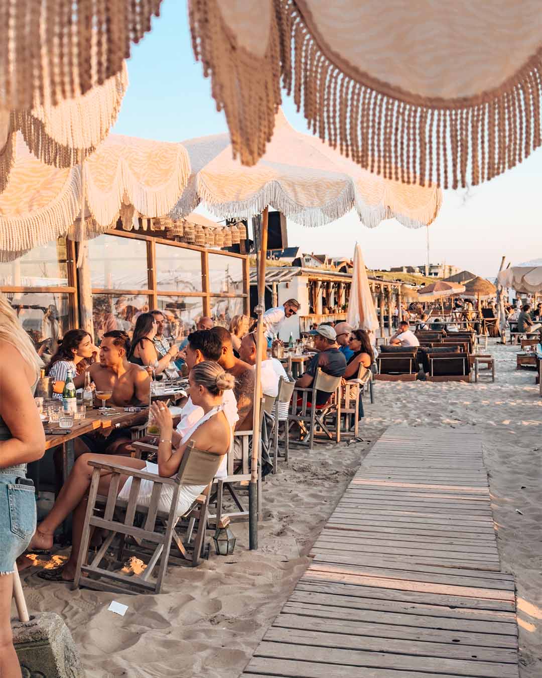 Mensen in de zon aan tafel in het zand