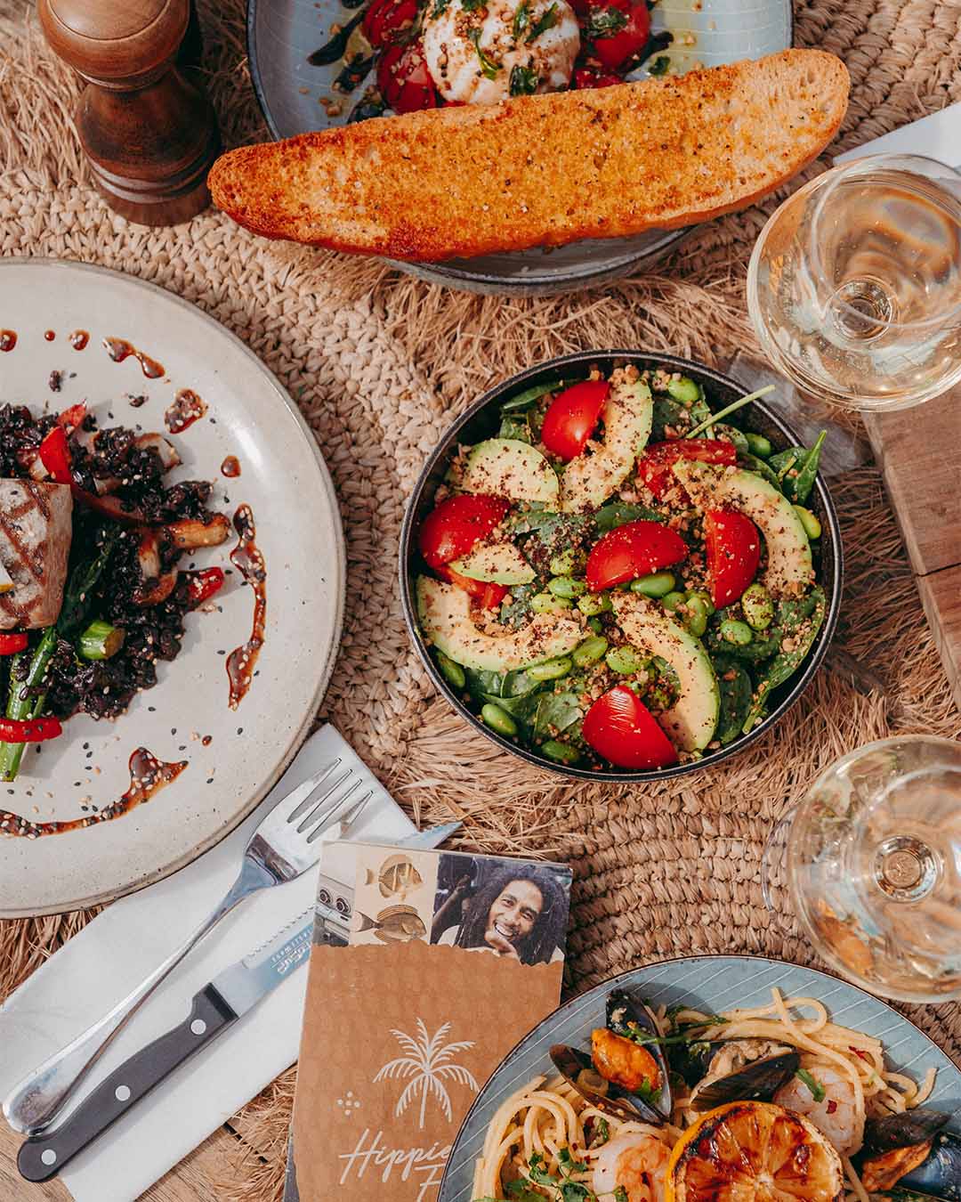 Bovenaanzicht diner met green salad, tonijnsteak en wijn